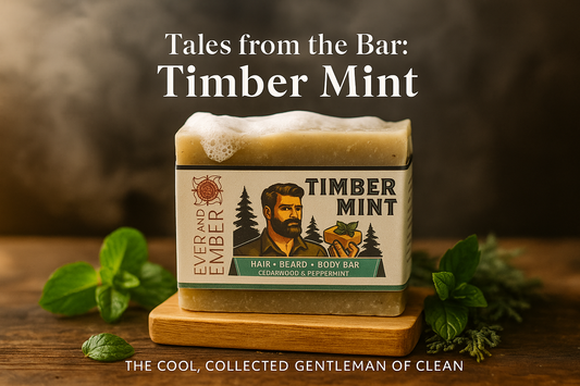 Rustic wooden bathroom counter with a natural mint and cedarwood soap bar labeled Timber Mint by Ever & Ember, surrounded by fresh mint leaves and cedar sprigs with steam rising in the background.”