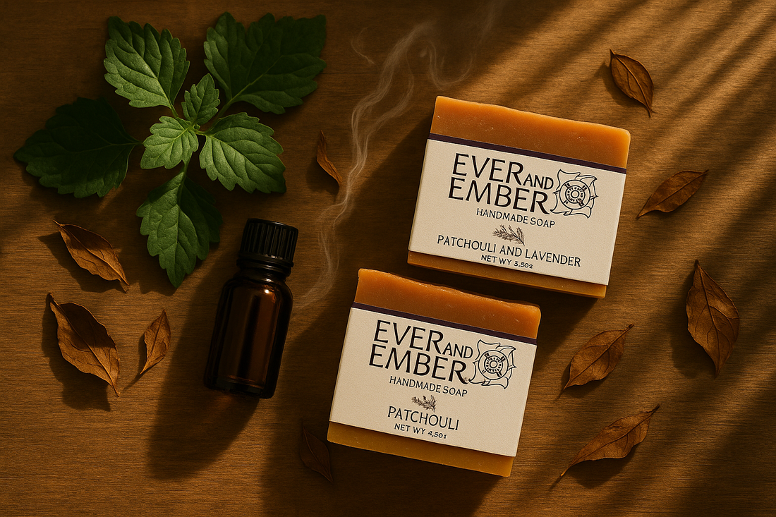 Flat-lay of patchouli leaves, amber essential-oil bottle, and Ever & Ember natural soap bars on rustic wood surface — earthy, warm tones symbolizing the history and natural essence of Patchouli.